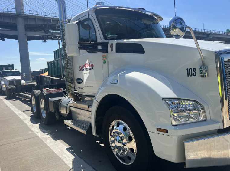 White semi-truck parked under a clear blue sky.